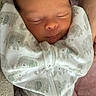 Oakland is registered to the contest to win money with this photo: newborn, baby, sleeping, infant, onesie, elephant_pattern, wrapped, arms, cozy, soft, cute, child, peaceful, resting, person, closeup, indoor, clothing, fabric, skin