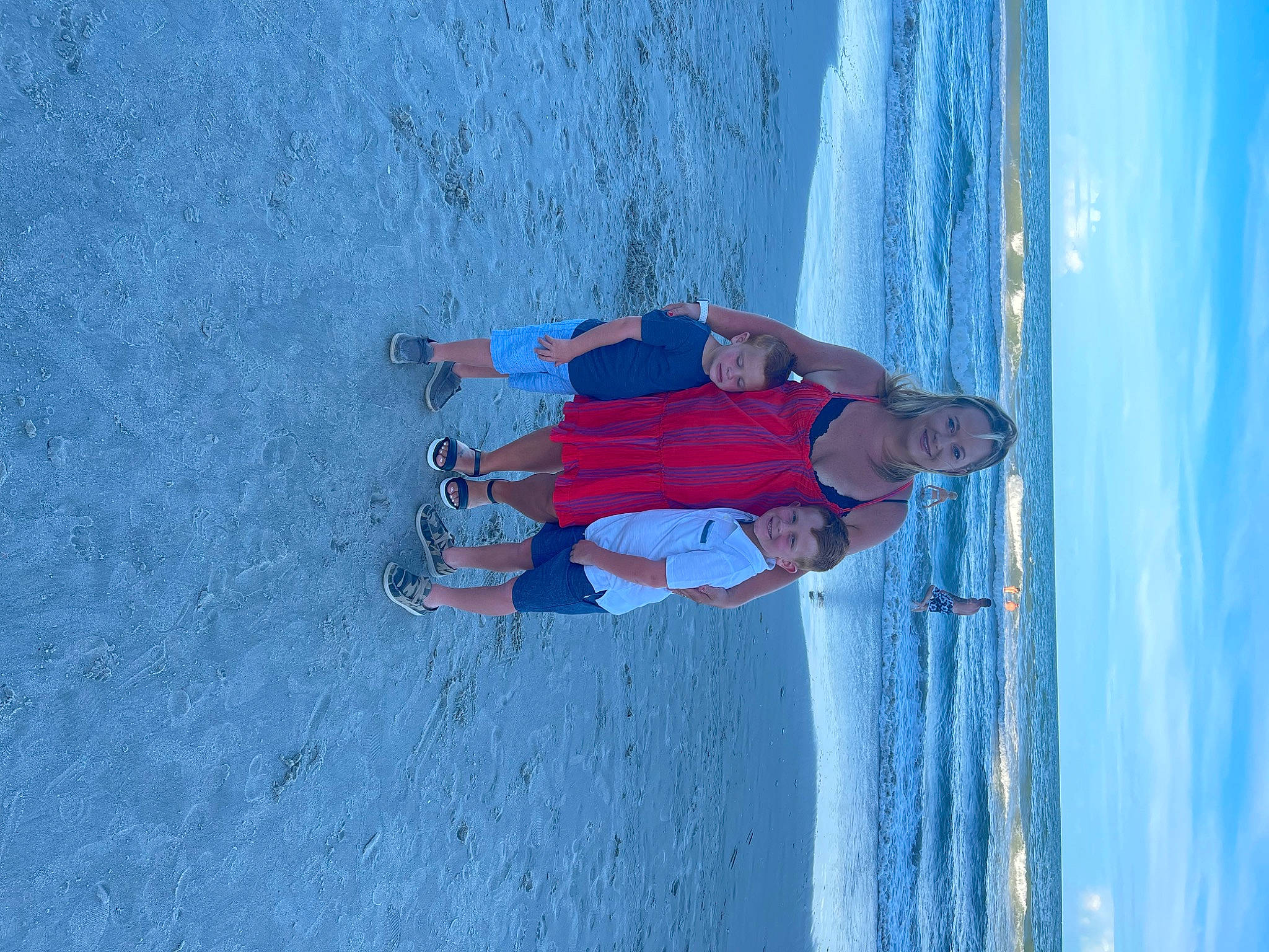 Rowan is registered to the contest to win money with this photo: adventure, azure, beach, blue, body_of_water, cloud, elbow, electric_blue, fun, joy, leisure, person, recreation, sand, sky, slope, smile, standing, t_shirt, water