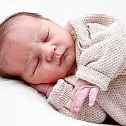 Imrân participe au concours pour gagner de l'argent avec cette photo : baby, newborn, sleeping, infant, knitted_clothing, cozy, peaceful, cute, hand, face, skin, resting, portrait, closeup, soft, child, person, indoors, blanket, warm