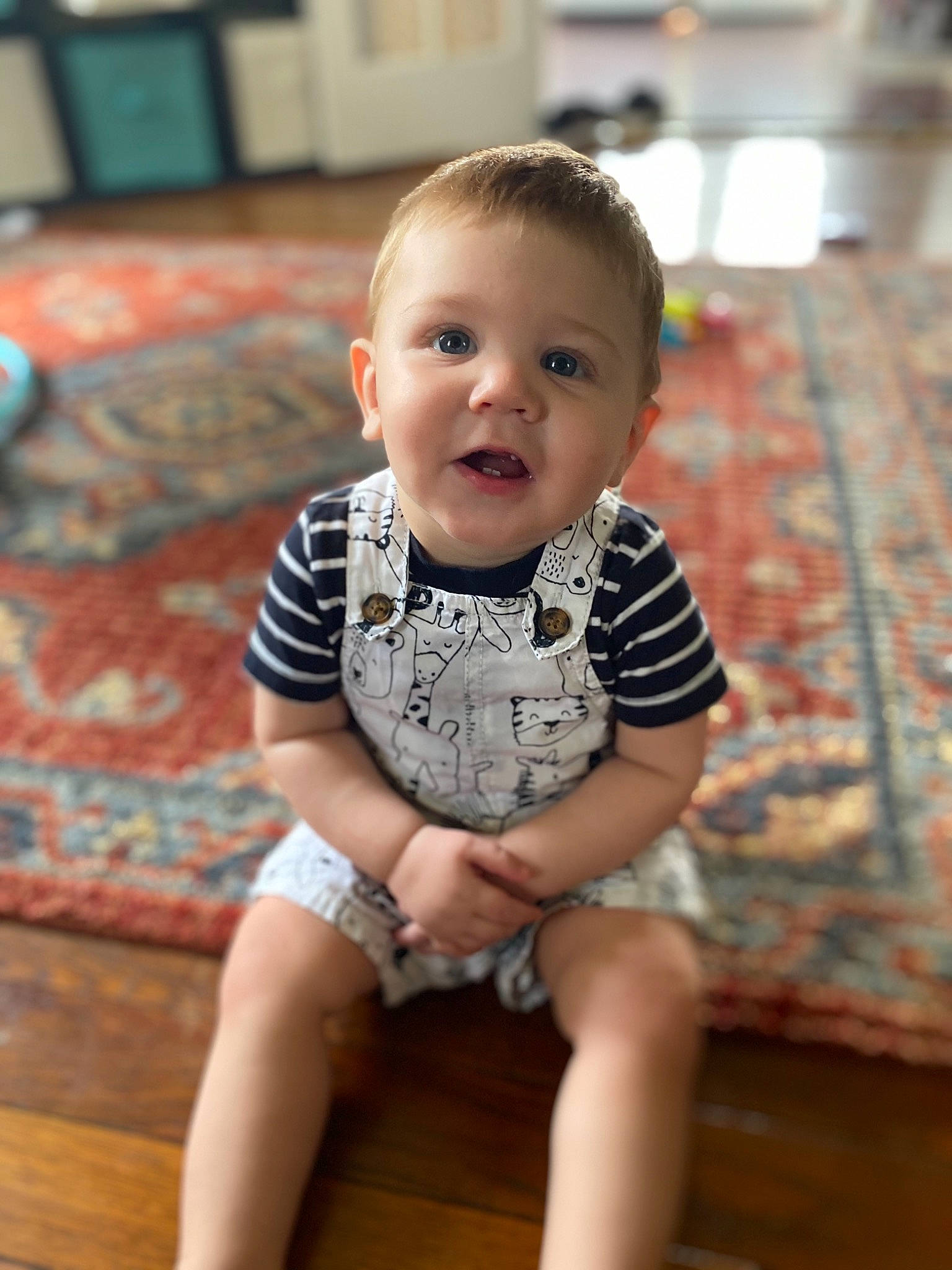 Chandler is registered to the contest to win money with this photo: baby, baby_toddler_clothing, cheek, child, chin, face, floor, flooring, head, person, sitting, skin, smile, toddler