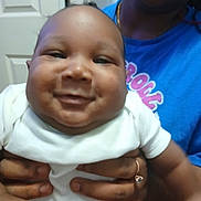 Zyutay joined the competition — help win amazing prizes! baby, smile, person, adult, indoor, holding, hands, white_clothing, blue_shirt, door, face, closeup, joy, happy, skin, portrait, human, child, family, candid
