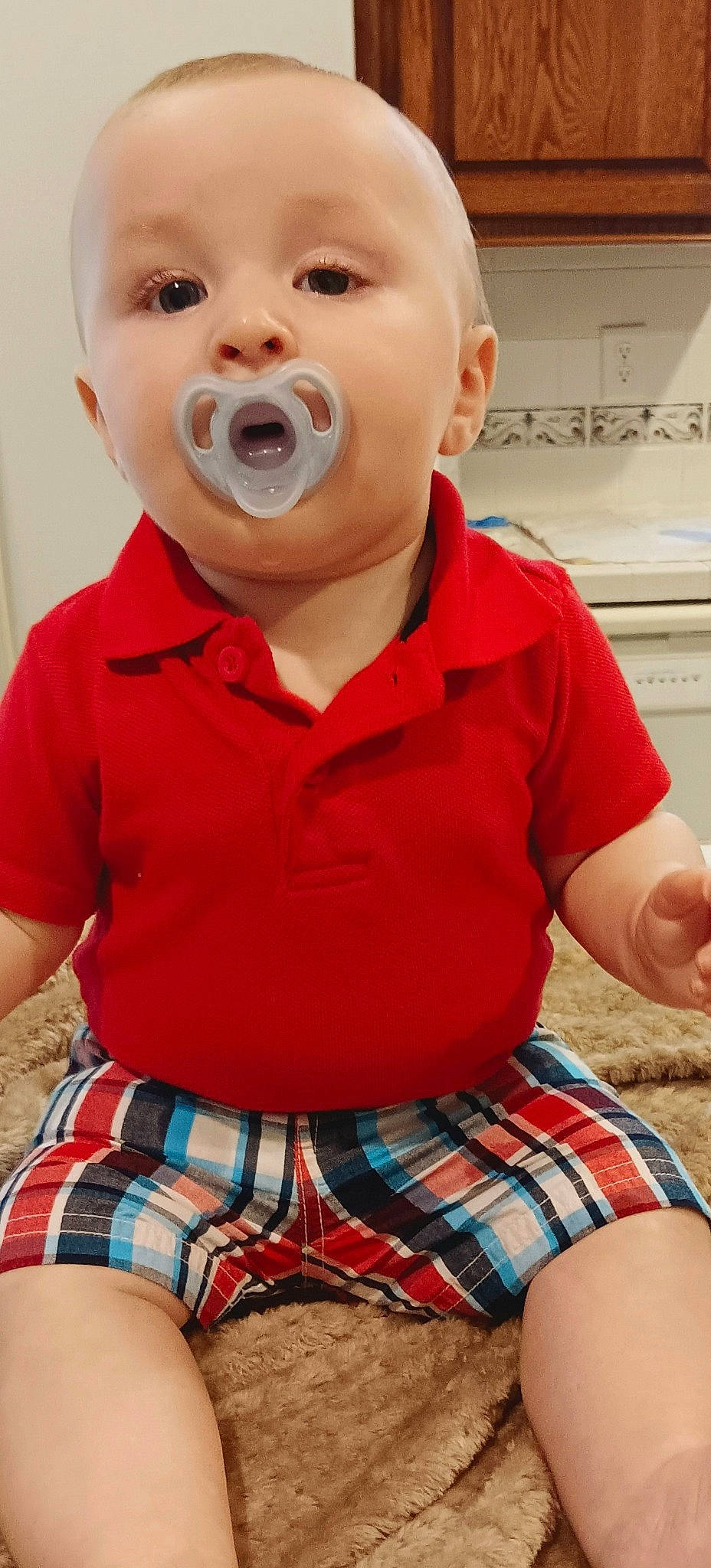 Clyde is registered to the contest to win money with this photo: baby_toddler_clothing, cheek, chin, face, green, happy, head, iris, lip, mouth, neck, nose, outerwear, person, plaid, red, skin, sleeve, tartan, toddler
