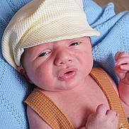 Landon is registered to the contest to win money with this photo: baby, newborn, infant, face, cap, hat, clothing, blue_blanket, knit, soft_texture, skin, portrait, close_up, cute, small_hands, expression, lying_down, warm, cozy, child