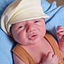 baby, newborn, infant, face, cap, hat, clothing, blue_blanket, knit, soft_texture, skin, portrait, close_up, cute, small_hands, expression, lying_down, warm, cozy, child