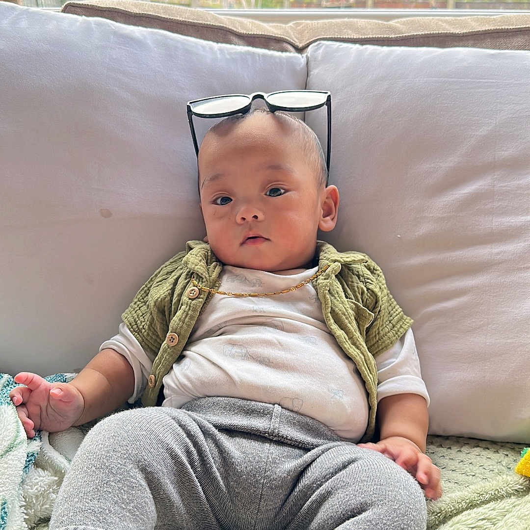 Rawlex is registered to the contest to win money with this photo: baby, blanket, bodypart, clothing, couch, cushion, face, finger, furniture, hand, hat, head, homedecor, knitwear, pants, person, photography, portrait, sitting, sweater