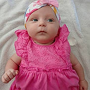 Myla participe au concours pour gagner de l'argent avec cette photo : baby, infant, pink_dress, headband, bow, blue_eyes, towel, lying_down, cute, child, soft_texture, clothing, portrait, skin, small_hand, adorable, young, indoors, expression, baby_face