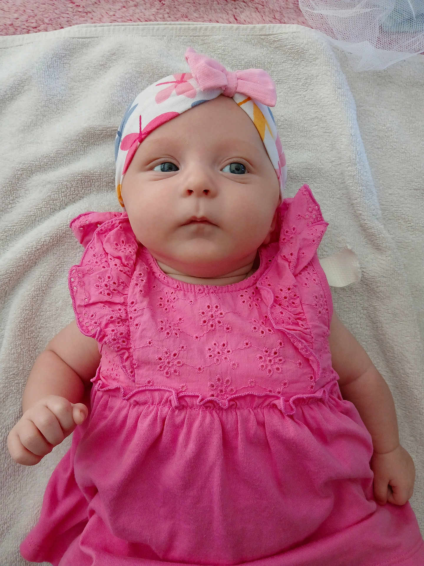 Myla participe au concours pour gagner de l'argent avec cette photo : baby, infant, pink_dress, headband, bow, blue_eyes, towel, lying_down, cute, child, soft_texture, clothing, portrait, skin, small_hand, adorable, young, indoors, expression, baby_face