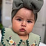 baby, child, face, headband, bow, green_dress, embroidery, cute, portrait, indoor, expression, closeup, button, skin, person, infant, fashion, clothing, adorable, young