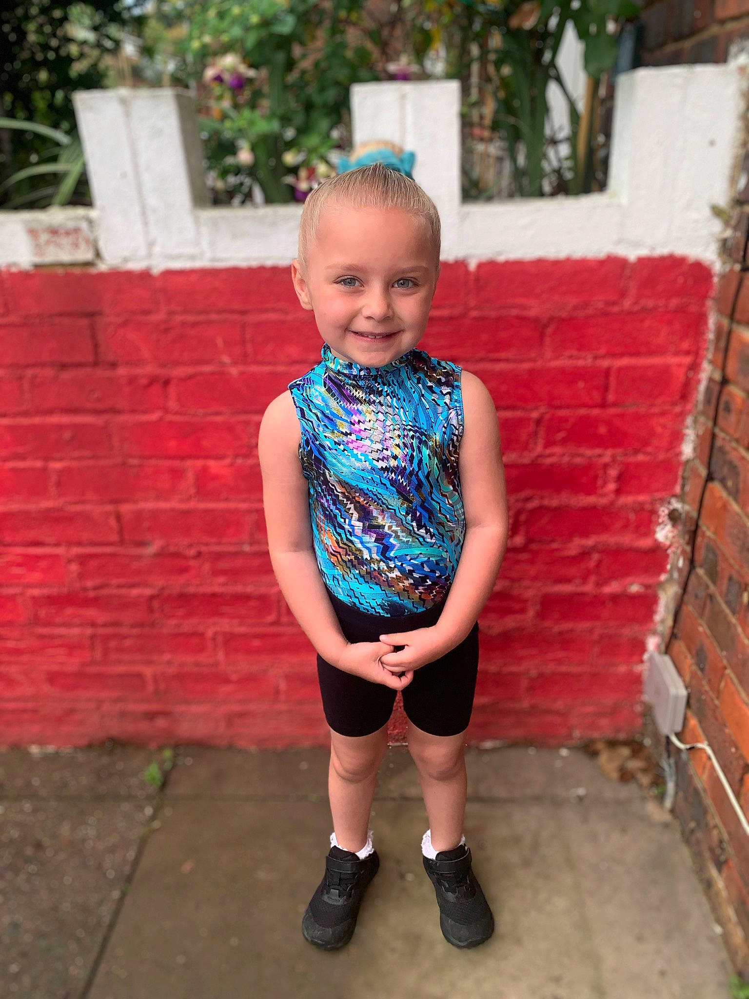 Daisie is registered to the contest to win money with this photo: baby_toddler_clothing, brick, brickwork, electric_blue, fashion_accessory, happy, joy, leisure, magenta, neck, pattern, person, pink, plant, recreation, sitting, sleeve, smile, summer, t_shirt