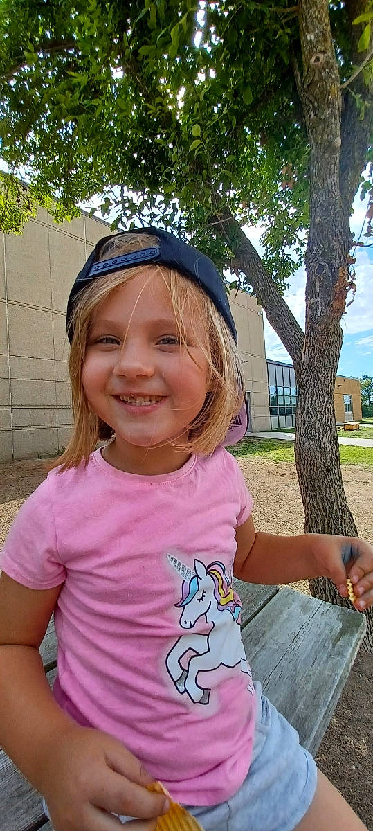 Eleanor is registered to the contest to win money with this photo: cap, cool, electric_blue, eye, facial_expression, fun, gesture, grass, happy, headwear, joy, leisure, person, pink, plant, recreation, sleeve, smile, summer, t_shirt