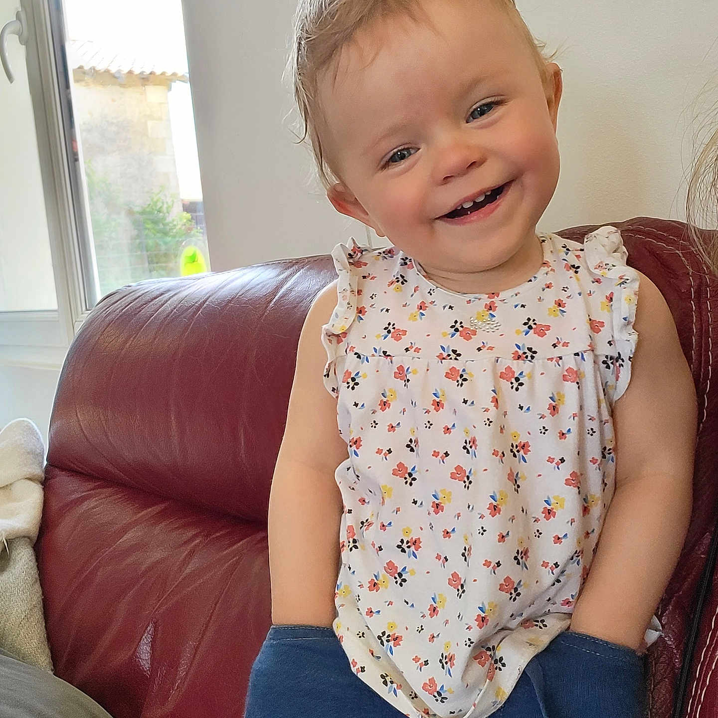 Lya participe au concours pour gagner de l'argent avec cette photo : architecture, baby, blouse, building, clothing, couch, cushion, face, furniture, happy, head, homedecor, indoors, livingroom, pants, person, photography, portrait, room, sitting