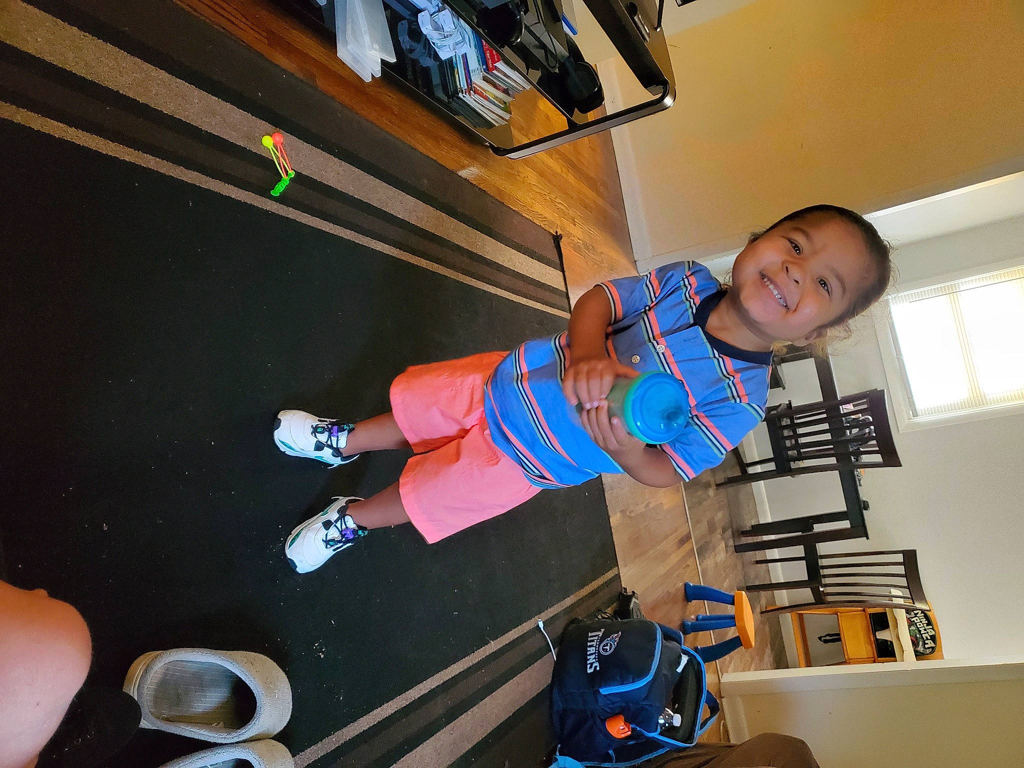 Dwaine is registered to the contest to win money with this photo: baby, baby_toddler_clothing, chair, child, elbow, electric_blue, fun, human_leg, joy, knee, leisure, person, play, recreation, room, shelf, shorts, smile, sportswear, t_shirt