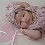 baby, infant, pink, headband, bow, heart_shaped_sign, 1_month, milestone, cute, portrait, lying_down, soft_texture, child, young, adorable, close_up, peaceful, clothing, fabric, ribbon