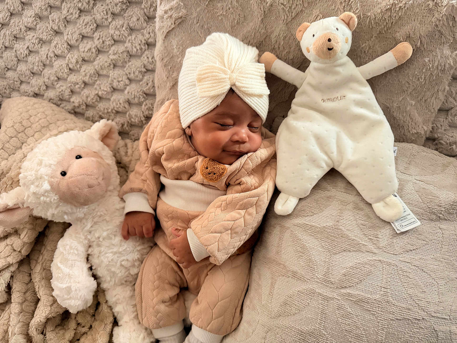 Ashanti a rejoint le concours — aidez-le/la à gagner de superbes lots ! baby, sleeping, plush_toy, lamb, bear, blanket, knitwear, turban, cozy, soft, cuddly, child, cute, indoors, comfort, resting, texture, neutral_colors, peaceful, portrait