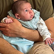 Gabriel participe au concours pour gagner de l'argent avec cette photo : baby, infant, arms, blanket, clothing, pajamas, person, human, skin, hand, face, expression, curious, holding, closeup, indoor, adult, comfort, warmth, portrait