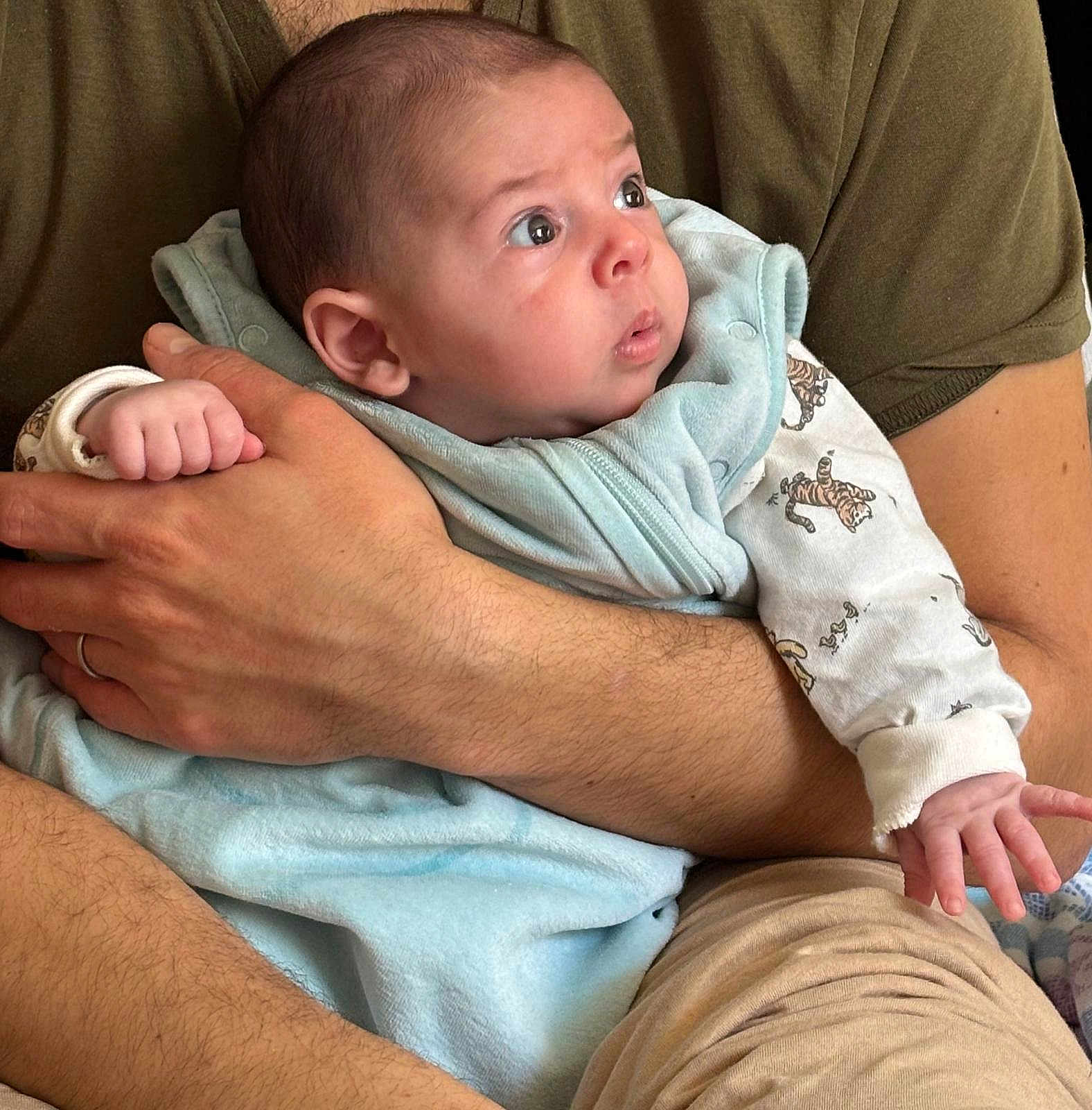 Gabriel participe au concours pour gagner de l'argent avec cette photo : baby, infant, arms, blanket, clothing, pajamas, person, human, skin, hand, face, expression, curious, holding, closeup, indoor, adult, comfort, warmth, portrait