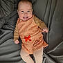 Nina participe au concours pour gagner de l'argent avec cette photo : baby, infant, child, smile, tongue_out, orange_dress, bow, tights, bed, blanket, gray_bedspread, cheeks, hands, portrait, laying_down, cozy, happy, cute, soft_light, closeup