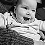 Nina participe au concours pour gagner de l'argent avec cette photo : baby, infant, smiling, laughing, black_and_white, portrait, close_up, face, cheeks, eyes, mouth, clothing, sweater, hand, arm, cozy, indoor, family, parent, adorable