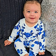 Joy is registered to the contest to win money with this photo: baby, blanket, blue_eyes, child, clothing, couch, cute, earrings, face, floral_pajamas, happy, indoor, infant, photography, pigtails, portrait, sequin_pillow, sitting, smile, toes
