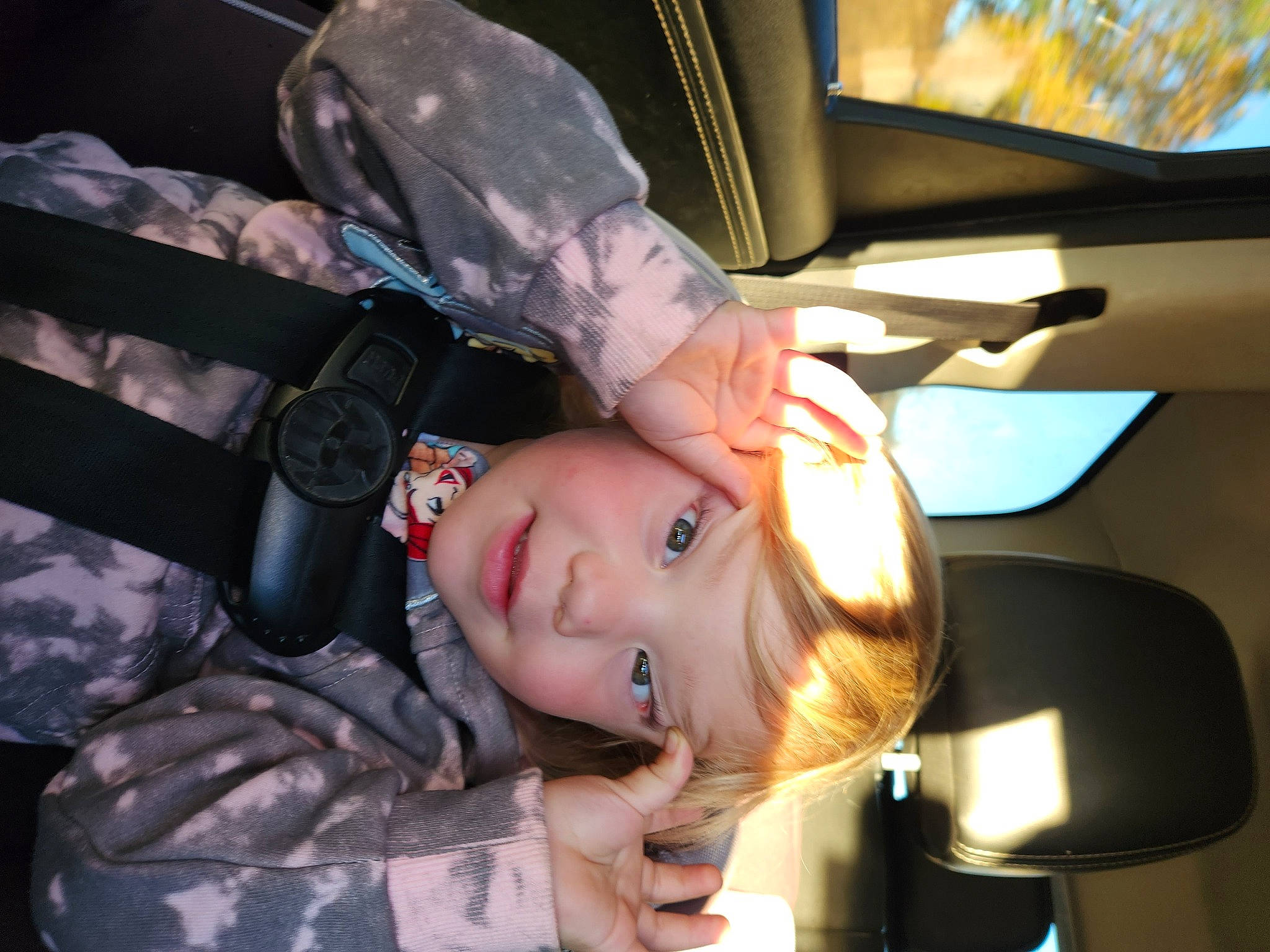 Dallas is registered to the contest to win money with this photo: auto_part, automotive_design, automotive_exterior, automotive_lighting, automotive_window_part, car_seat, child, family_car, gesture, headwear, luxury_vehicle, person, sitting, toddler, vehicle_door, window, windshield