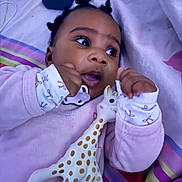 Anayah a rejoint le concours — aidez-le/la à gagner de superbes lots ! baby, child, toy, giraffe_toy, pink_clothing, bed, blanket, lying_down, hand, face, eyes, infant, cute, indoor, soft_toy, sleepwear, expression, person, comfort, closeup