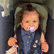 Leya a rejoint le concours — aidez-le/la à gagner de superbes lots ! baby, pacifier, stroller, child, blue_outfit, soft_toy, smiling, happy, curly_hair, seatbelt, infant, cute, indoor, person, portrait, safety_harness, young_child, holding, seated, face