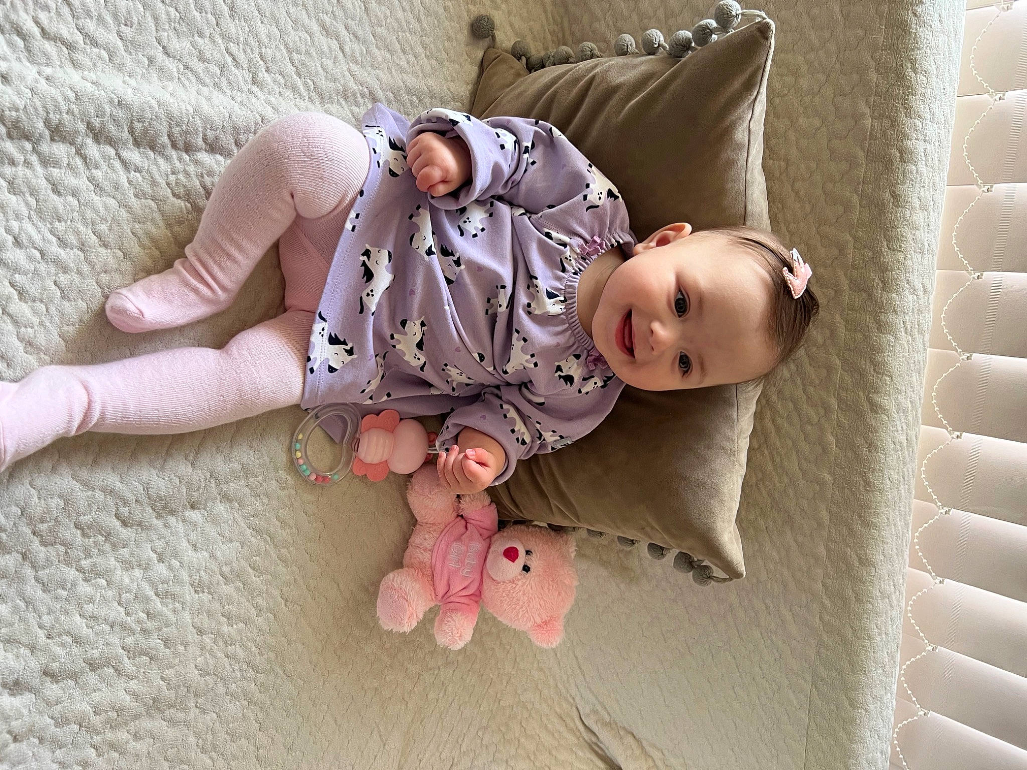 Angelina is registered to the contest to win money with this photo: arm, baby_toddler_clothing, barefoot, child, comfort, finger, floor, flooring, foot, gesture, happy, human_body, human_leg, joint, joy, leg, linens, person, pink, skin