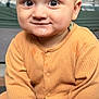 Azaan is registered to the contest to win money with this photo: baby, infant, child, onesie, orange_clothing, sitting, drool, cute, face, hands, feet, portrait, indoor, person, young_child, expression, closeup, skin, head, eyes