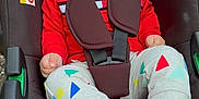 Azaan is registered to the contest to win money with this photo: baby, child, stroller, car_seat, smiling, red_clothing, striped_socks, colorful_pants, outdoor, happy, seatbelt, infant, toddler, person, cute, bright_colors, sitting, baby_face, playful, casual