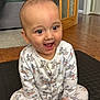 baby, child, infant, pajamas, mickey_mouse, sitting, happy, smiling, indoor, floor, wood_floor, black_mat, face, hands, cute, clothing, home, door, carpet, person