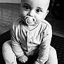 Azaan joined the competition — help win amazing prizes! baby, pacifier, pajamas, infant, child, sitting, floor, indoor, person, face, eyes, hands, footed_pajamas, mat, black_and_white, portrait, cute, young, expression, home