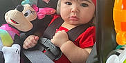 Brianna is registered to the contest to win money with this photo: baby, infant, child, car_seat, seatbelt, red_headband, bow, plush_toy, minnie_mouse, toy, car_interior, portrait, cheeks, wide_eyes, hand, buckle, clothing, safety_label, cute, travel