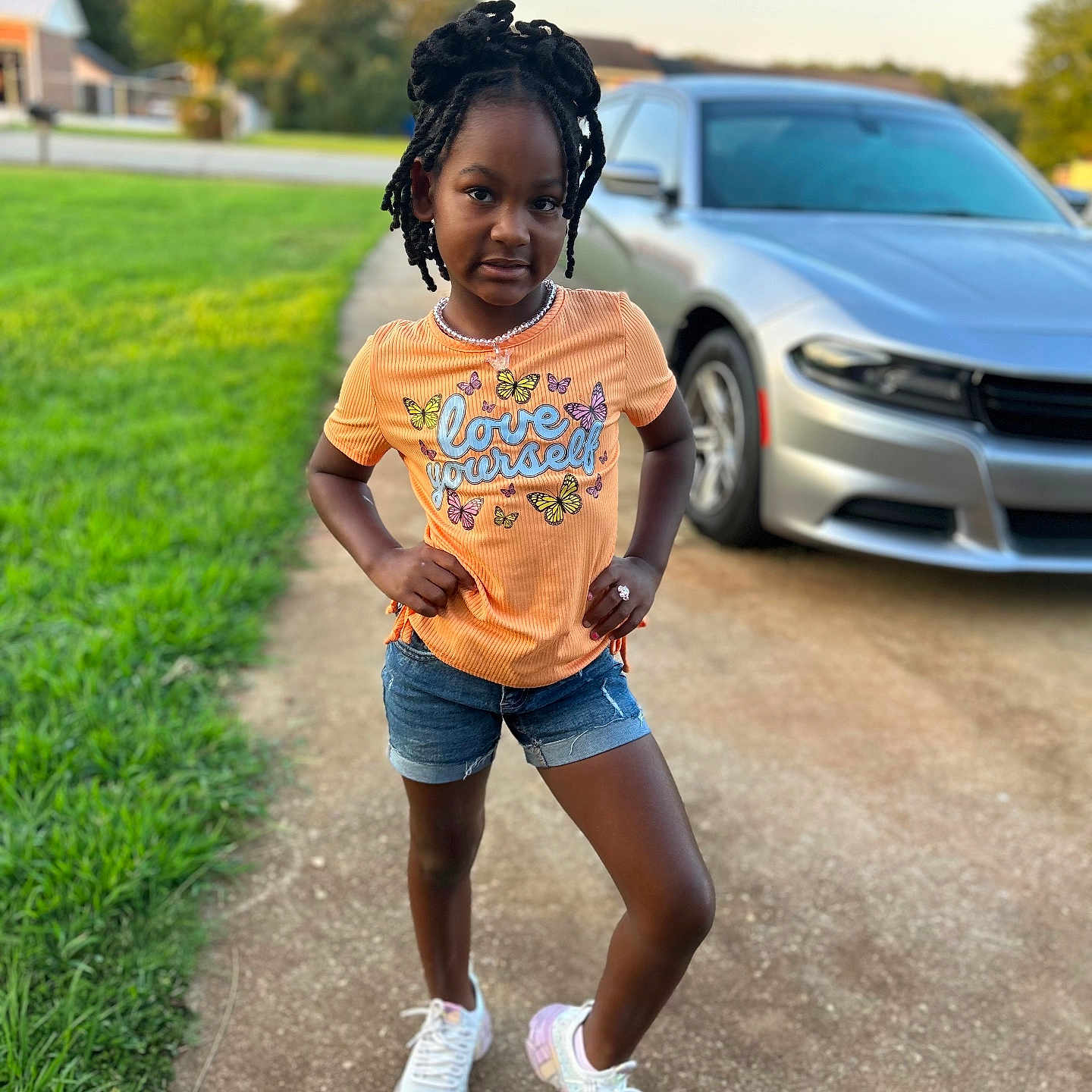 Aniyah is registered to the contest to win money with this photo: blackhair, car, child, clothing, face, female, girl, hair, head, machine, pedestrian, person, shorts, sitting, sleeve, standing, tire, transportation, vehicle, wheel