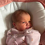 Arabella is registered to the contest to win money with this photo: newborn, baby, infant, pink_blanket, floral_onesie, face, expression, cushion, baby_seat, sleepwear, soft_texture, indoors, close_up, cute, small_hands, wrapped, resting, child, portrait, cozy