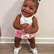 Khalani joined the competition — help win amazing prizes! baby, child, smiling, standing, white_socks, bows, pink_dress, white_top, floor, wooden_floor, indoor, happy, cute, person, portrait, toddler, hair_bows, skin, hands, feet