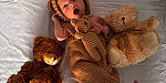 Nolan a rejoint le concours — aidez-le/la à gagner de superbes lots ! baby, bear_ears, bed, child, cozy, cute, expression, foot, hand_near_head, indoor, infant, knitted_outfit, lying_down, newborn, sleepwear, soft_toys, stuffed_animal, teddy_bear, warm_clothing, white_sheet