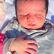 Muhammad is registered to the contest to win money with this photo: newborn, baby, sleeping, infant, hand, face, clothing, grey_outfit, sheep_pattern, flower_petals, red_flower, yellow_flower, white_blanket, soft_texture, peaceful, closeup, portrait, skin, cute, resting