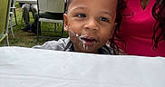 Jayse joined the competition — help win amazing prizes! toddler, child, face, cake, mouth, tablecloth, woman, pink_clothing, outdoor, grass, chair, table, people, party, food, celebration, smile, portrait, casual, gathering