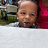 toddler, child, face, cake, mouth, tablecloth, woman, pink_clothing, outdoor, grass, chair, table, people, party, food, celebration, smile, portrait, casual, gathering