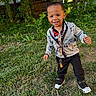Jayse joined the competition — help win amazing prizes! toddler, child, grass, outdoor, lollipop, smiling, jacket, sneakers, trees, fence, sunlight, playful, happy, person, young_child, nature, casual_clothing, greenery, daylight, portrait