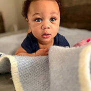 Saint joined the competition — help win amazing prizes! baby, child, curly_hair, blue_eyes, blanket, indoor, portrait, close_up, soft_texture, cute, infant, young_child, face, expression, curiosity, clothing, person, focus, warm_lighting, background_blur