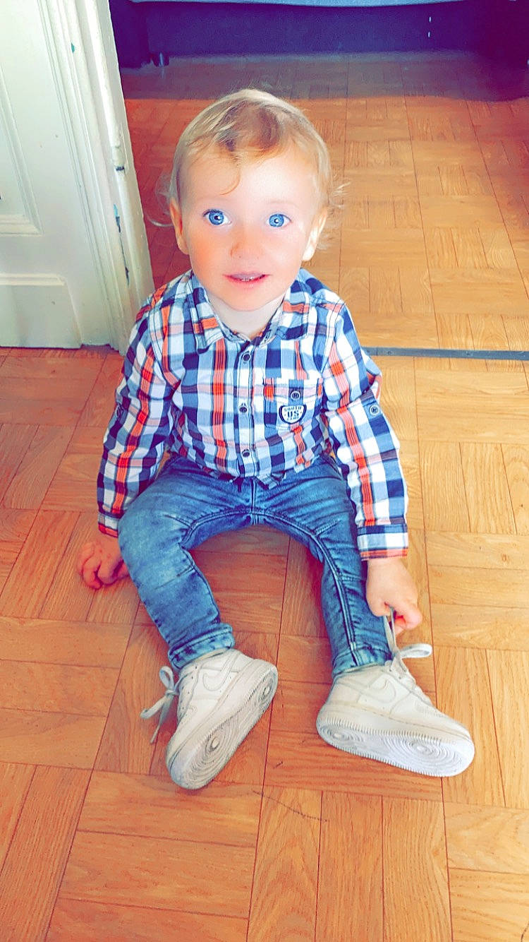 Brandon participe au concours pour gagner de l'argent avec cette photo : baby_toddler_clothing, denim, door, dress_shirt, floor, flooring, footwear, hair, hardwood, knee, leg, pattern, person, plaid, shoe, sleeve, smile, standing, tartan, wood