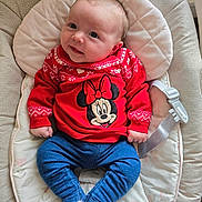 Arella joined the competition — help win amazing prizes! baby, infant, child, red_sweater, minnie_mouse, blue_pants, white_socks, baby_seat, cushion, smile, face, cute, indoor, clothing, childrens_wear, young_child, portrait, sitting, comfort, toy_character