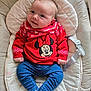 baby, infant, child, red_sweater, minnie_mouse, blue_pants, white_socks, baby_seat, cushion, smile, face, cute, indoor, clothing, childrens_wear, young_child, portrait, sitting, comfort, toy_character