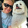 car, casual_clothing, closeup, companion, dog, fluffy, friendship, gold_earrings, happy, indoor, pet, portrait, seatbelt, short_hair, smiling, sunglasses, sunlight, tongue_out, white_dog, woman
