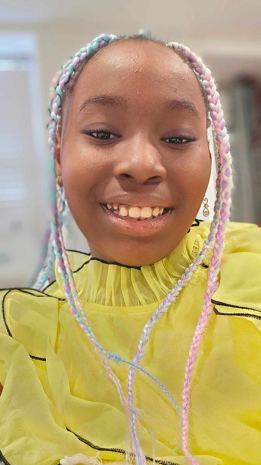 Amari is registered to the contest to win money with this photo: child, smiling, braided_hair, pastel_colors, yellow_clothing, portrait, indoor, young_person, happy, face, fashion, ruffles, earrings, closeup, person, casual, cute, skin, hairstyle, joyful