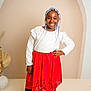 Amari a rejoint le concours — aidez-le/la à gagner de superbes lots ! child, girl, smiling, colorful_hair, braids, red_skirt, white_top, barefoot, posing, studio, minimalist, vase, dried_leaves, happy, fashion, portrait, young_person, standing, confident, indoor