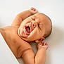 baby, infant, yawning, sleeping, blanket, skin, cute, arms, mouth, face, head, expression, newborn, resting, lying_down, indoors, soft_light, peaceful, comfort, closeup