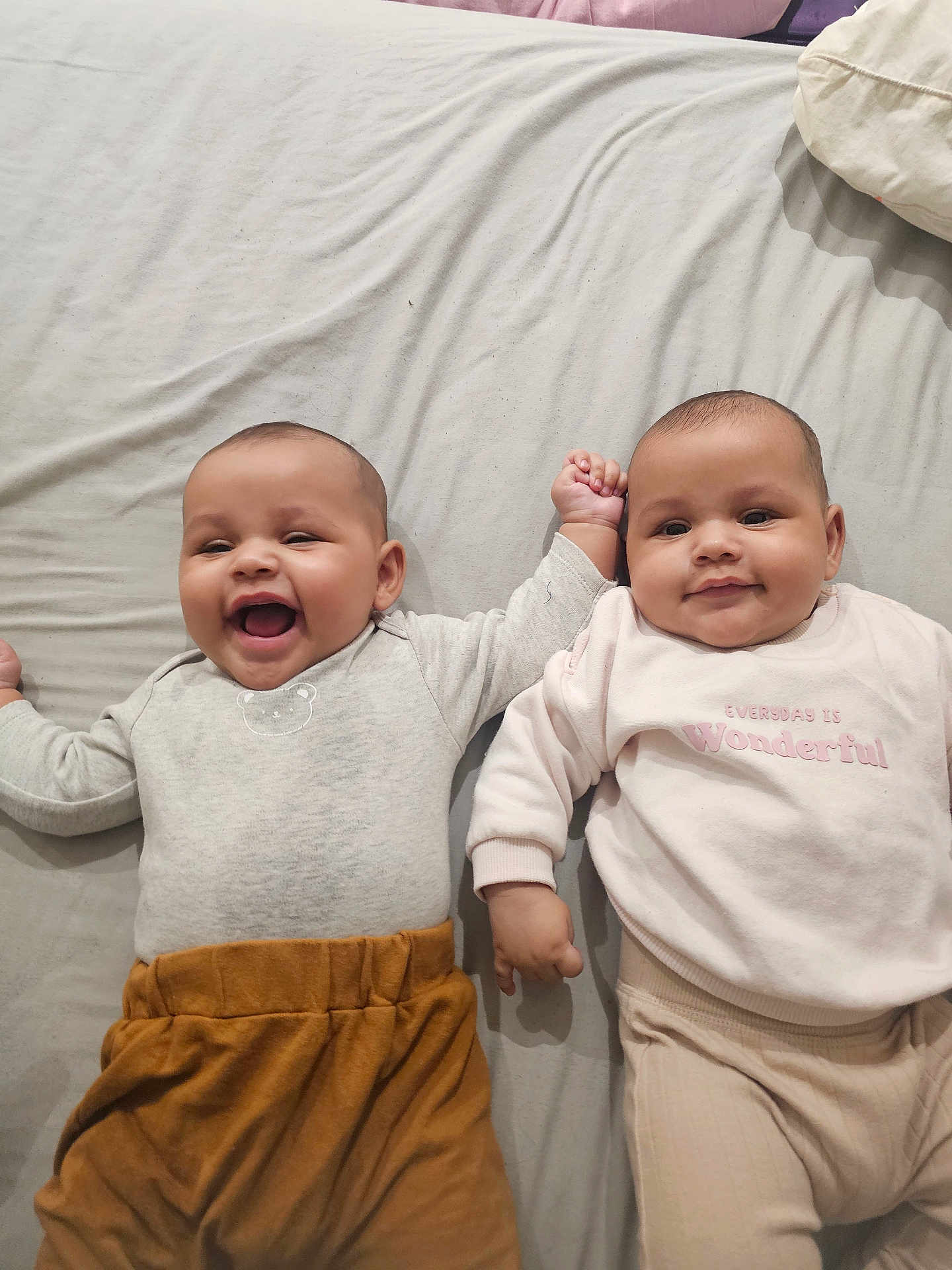 Amaya And Ariana joined the competition — help win amazing prizes! baby, babies, smiling, laughing, lying_down, bed, blanket, clothing, cute, infant, child, happy, hand_holding, toddler, indoor, portrait, skin, face, sleeve, pajamas