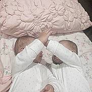 Amaya And Ariana is registered to the contest to win money with this photo: baby, infant, sleepwear, pajamas, twin, bed, pillow, floral, blanket, hand, cute, newborn, lying_down, indoor, soft, child, playful, matching_clothes, person, cozy